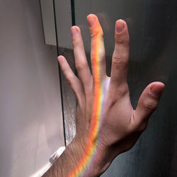 Close-up of human hand touching mirror