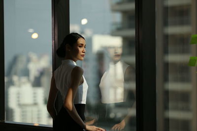 Close-up of woman looking through window