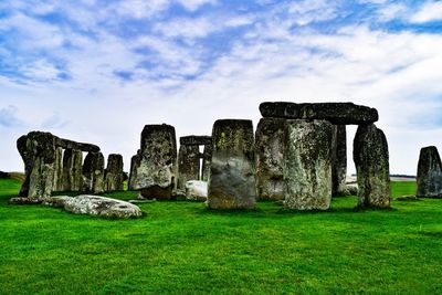 Built structure on landscape against cloudy sky