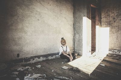 Man sitting on floor against wall