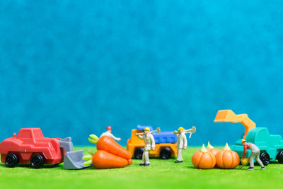 Close-up of toys and figurine on green table