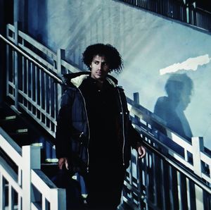 Portrait of young man standing against railing