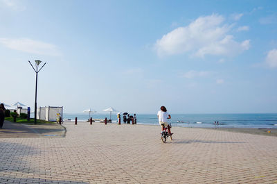 Rear view of woman riding bicycle on beach