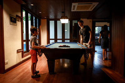 Midsection of kids playing pool 