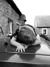 Full length portrait of boy by house against building