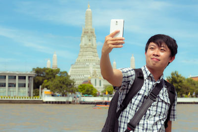 Portrait of mid adult man using smart phone in city