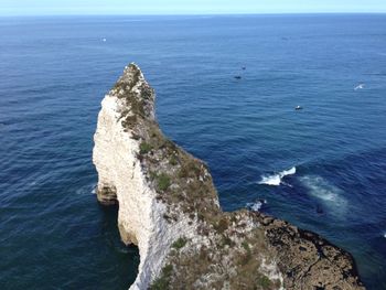 High angle view of rock formation in sea against sky