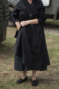 Low section of woman standing on field