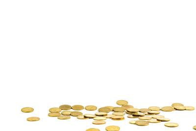 Close-up of coins on floor against white background