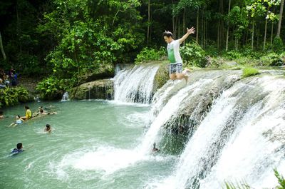 Full length of waterfall in forest