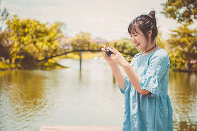 Young man using mobile phone in water