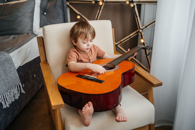 Little boy playing classical guitar. high quality photo