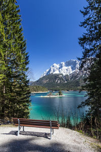 Scenic view of lake and mountains against clear blue sky