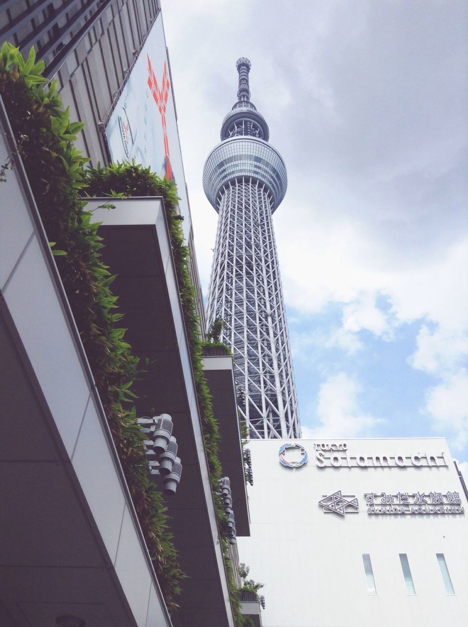 architecture, built structure, building exterior, sky, low angle view, communication, text, city, tower, tall - high, modern, western script, day, cloud - sky, skyscraper, outdoors, building, office building, travel destinations, no people