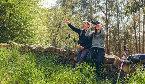 Woman sitting on mobile phone in forest