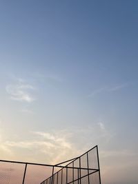 Low angle view of silhouette railing against sky