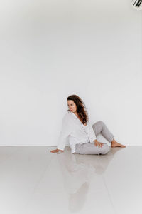 Girl sitting on the floor on a white background