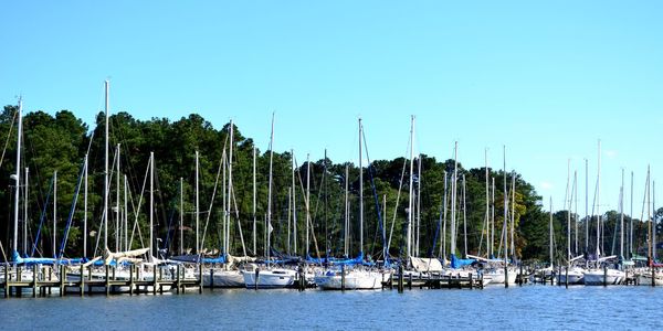 Panoramic view of boats moored against clear blue sky