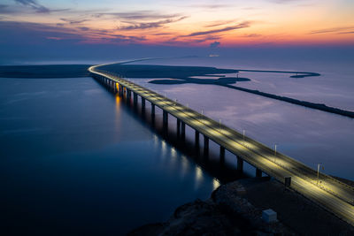 Kind fahd causeway over sea against sky during sunrise 