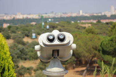 Fixed binoculars of parque del oeste in madrid, spain with the cityscape in the background