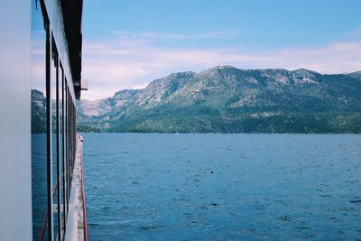 Scenic view of sea by mountains against sky