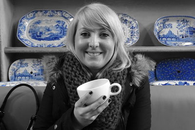 Portrait of smiling woman holding coffee cup