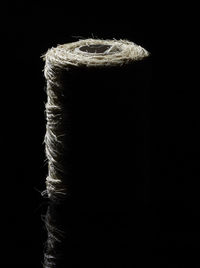 Close-up of rope on table against black background