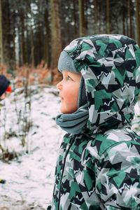 Portrait of boy in snow covered land