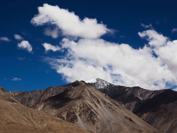 Scenic view of mountain range against cloudy sky