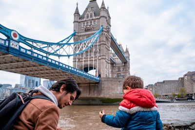Father and son by thames river in city