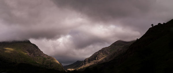 Low angle view of storm clouds over mountain