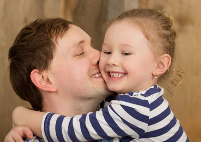 Close-up of smiling father and daughter at home