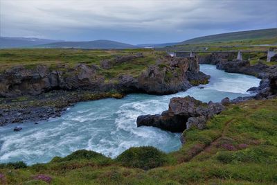 Scenic view of river amidst rock formation against cloudy sky