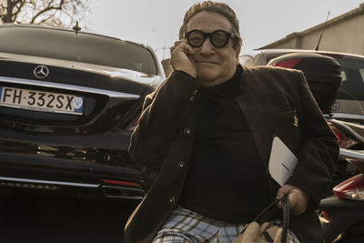 Portrait of man standing in car