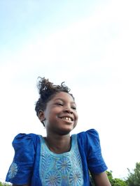 Portrait of a smiling young girl trough the blue sky