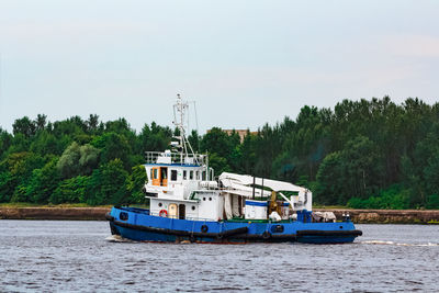 Boat sailing on river against sky