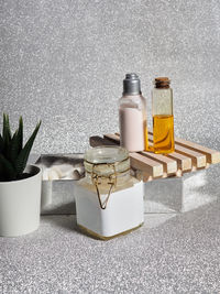 Set of cosmetics, oils, creams on a wooden stand on a silver background.