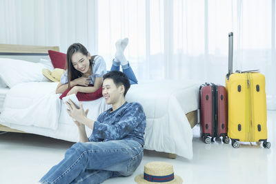 Happy young woman sitting on bed