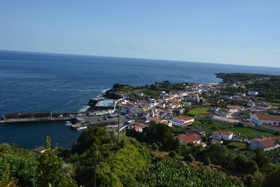 High angle view of townscape by sea against sky