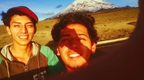 Portrait of smiling young couple against sky