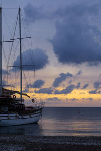 Sailboat sailing on sea against sky during sunset