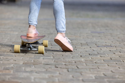 Low section of person skateboarding on street