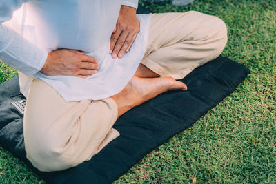 Male therapist performing reiki therapy self treatment holding hands over his stomach