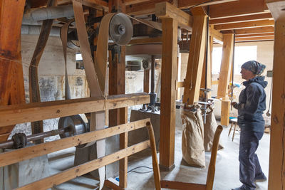 Woman in flour mill checking working machinery