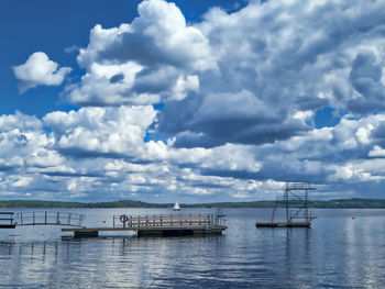 Sailboats moored in sea against sky