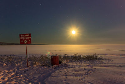 Scenic view of frozen lake at sunset