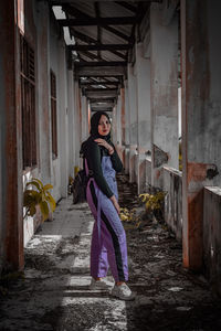 Portrait of woman standing by building