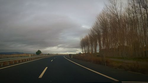 Road amidst trees against sky
