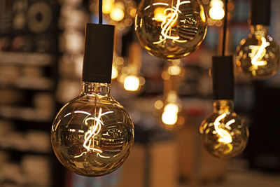 Many lighted bulbs hang from the ceiling inside the store