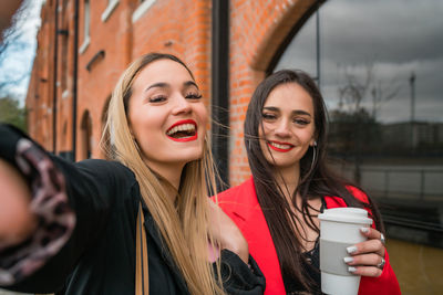 Portrait of a smiling young woman drinking water